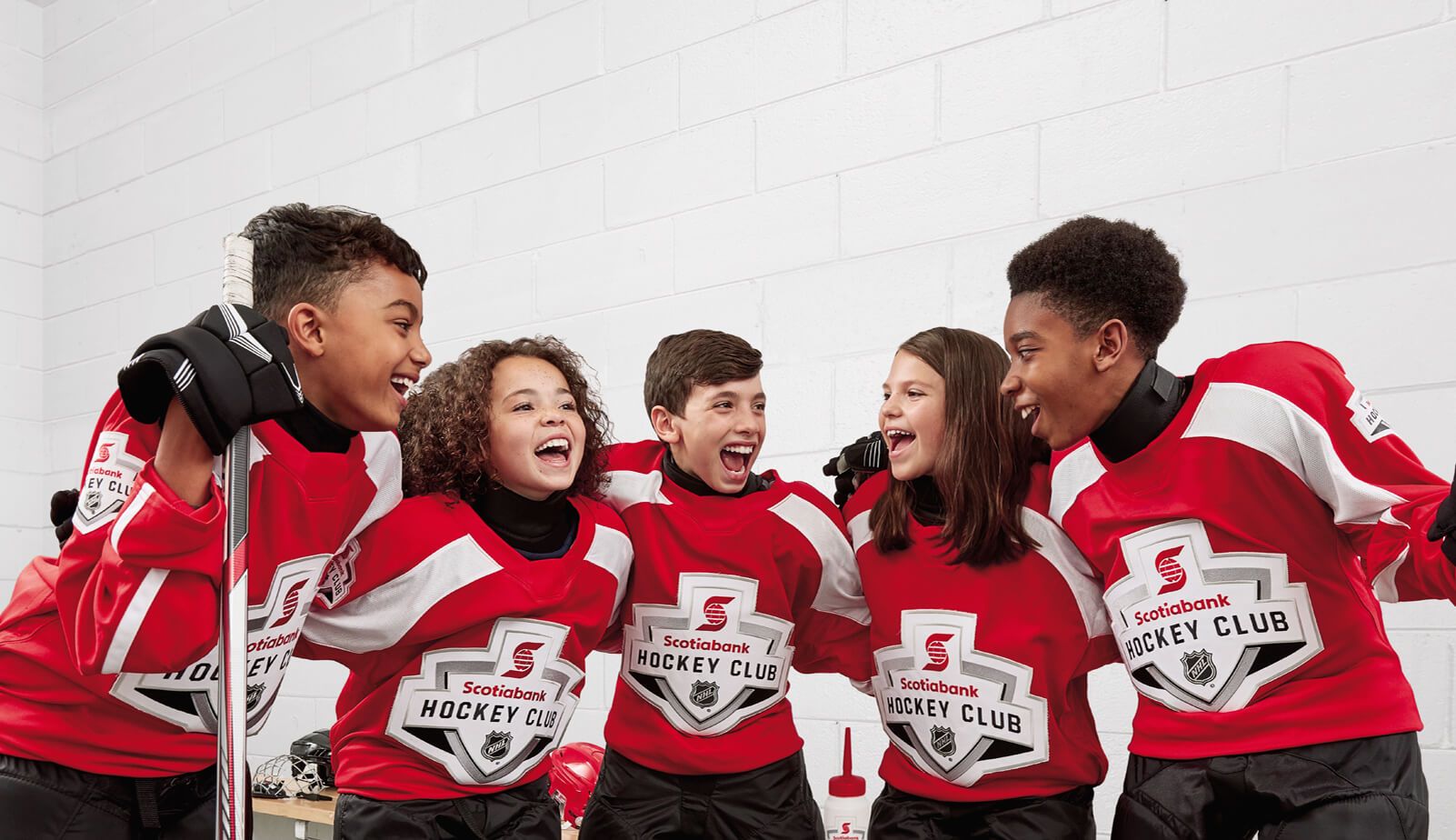 Hockey player kids smiling at each other.